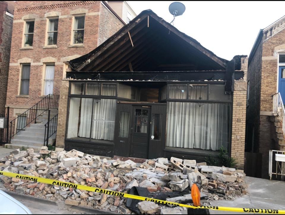 A brick building with a caution tape around it